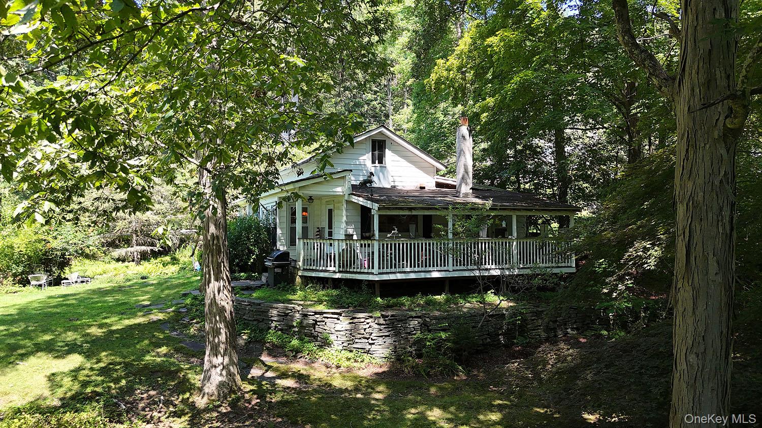 66 Raspberry Park Road Long Eddy, NY 12760 - Photo 5 of 36 Rear view of house with a lawn, covered porch, and a view of trees