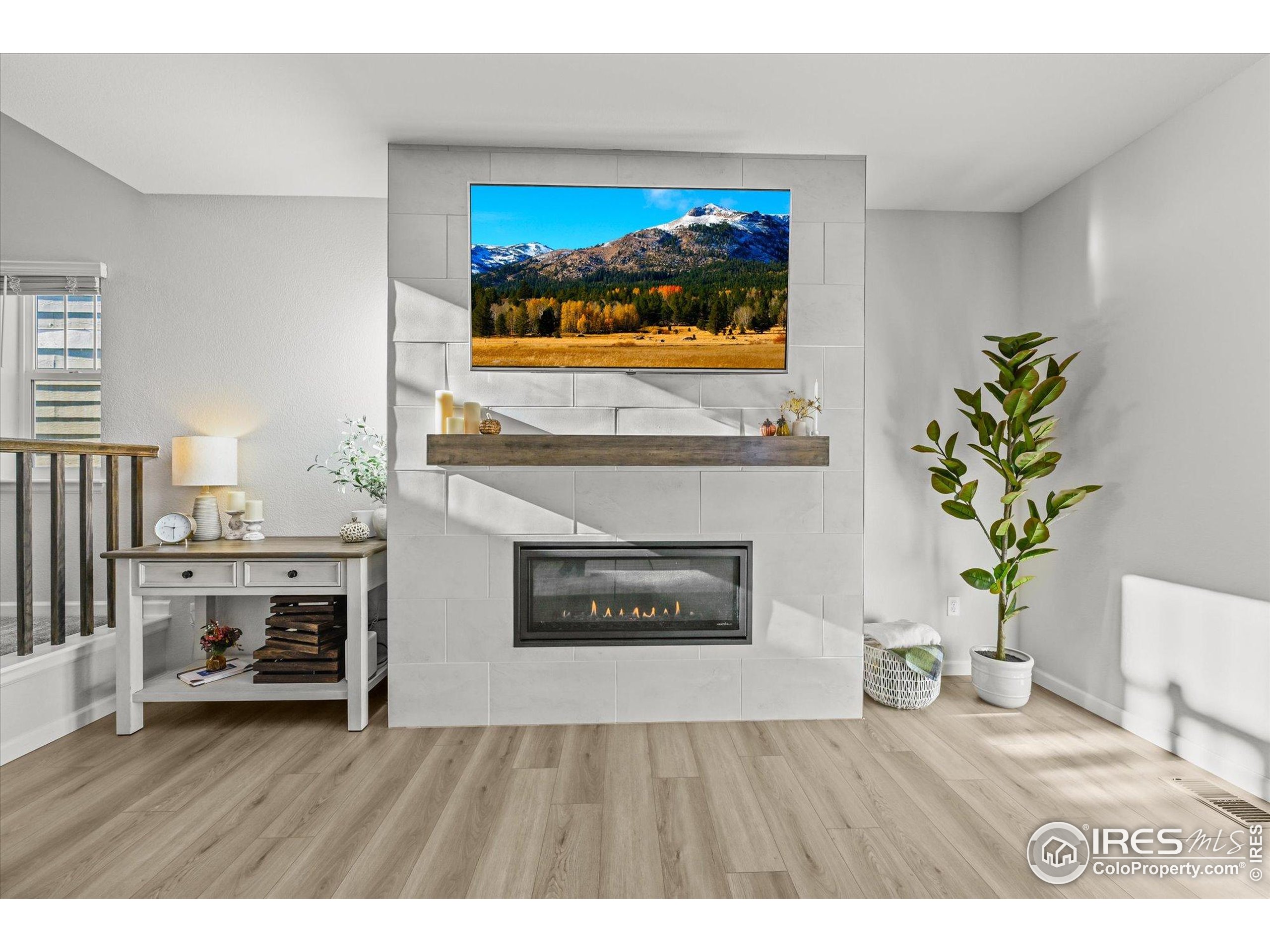 950 Rustling Street Windsor, CO 80550 - Photo 16 of 49 a living room with furniture and a fireplace with kitchen view