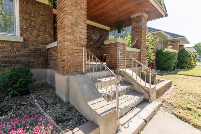 227 West 200 North Logan, UT 84321 - Photo 6 of 44 Brick facade featuring a covered porch with a wood-finish ceiling, concrete stairs, and metal railings