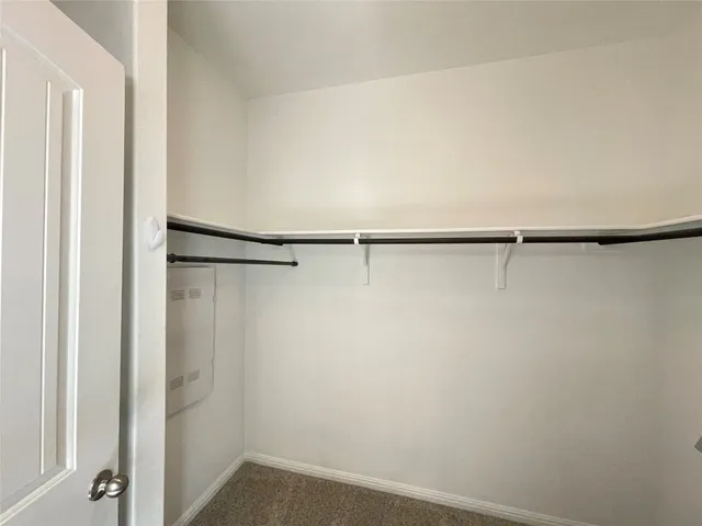 a view of walk in closet with empty racks