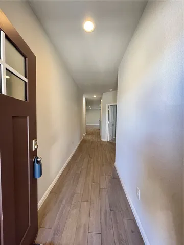 a view of a hallway with wooden floor