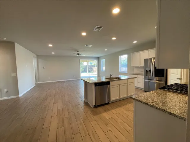 a large kitchen with a sink and a stove top oven