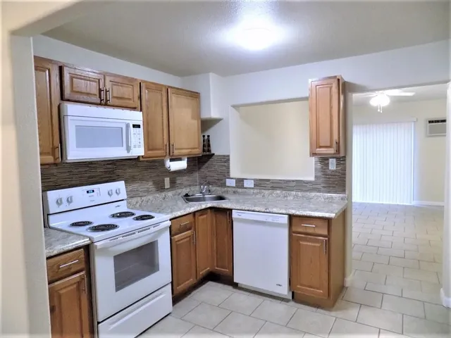 a view of an empty room with a ceiling fan and window