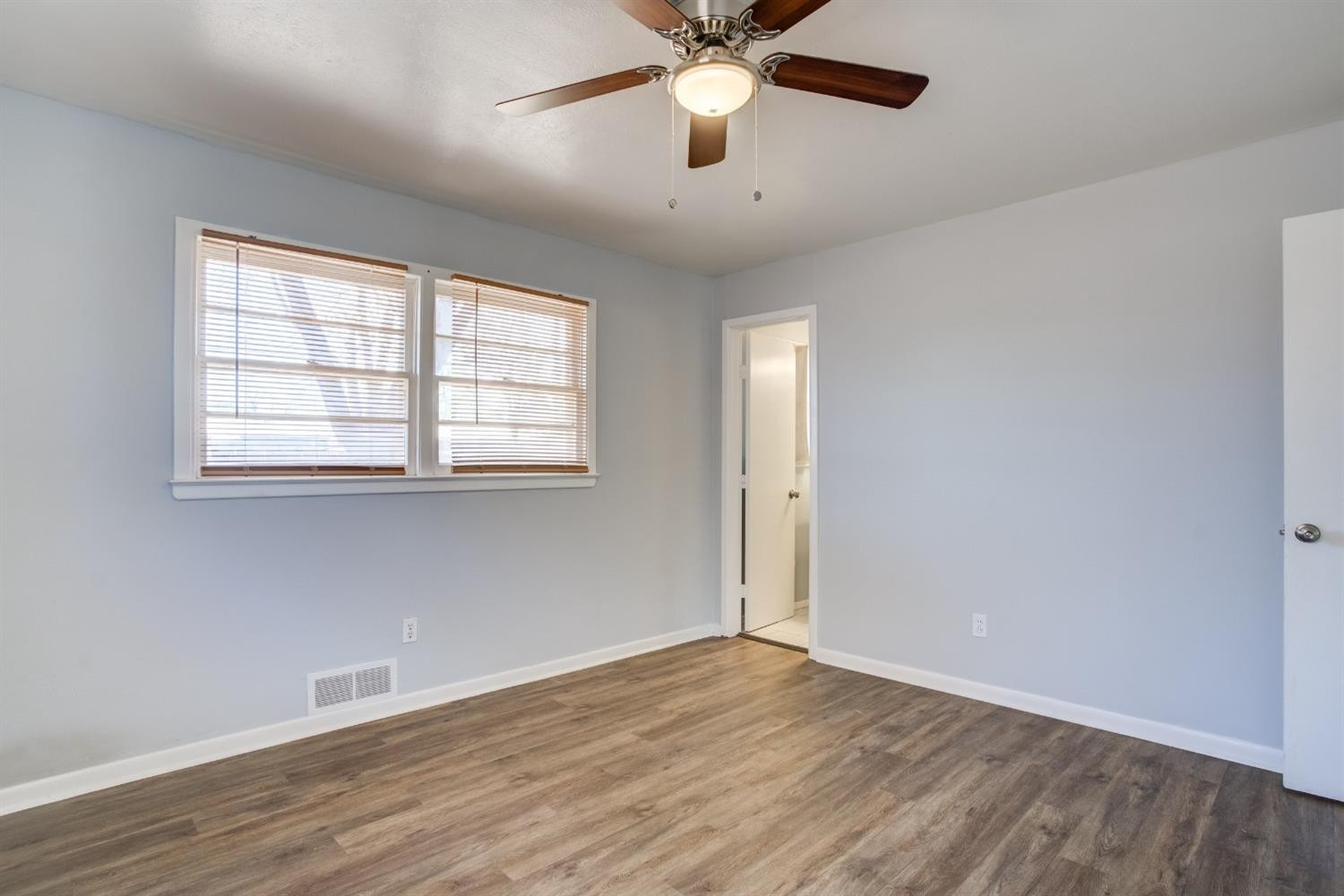 3011 44th Street Lubbock, TX 79413 - Photo 13 of 19 an empty room with wooden floor fan and windows