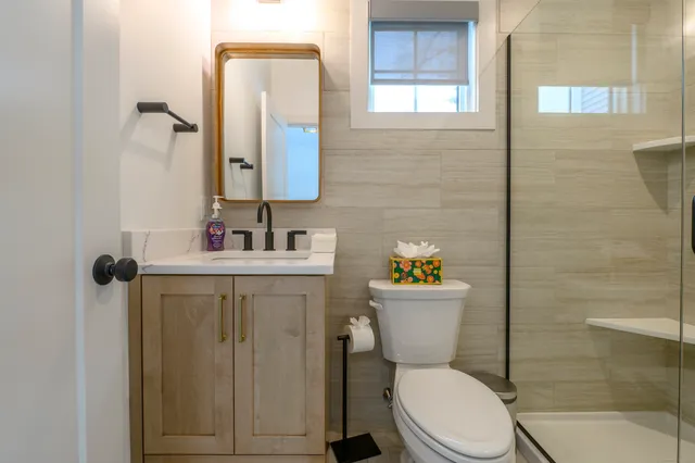 a bathroom with a sink mirror vanity and toilet