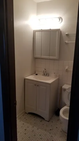 a bathroom with a toilet sink and mirror