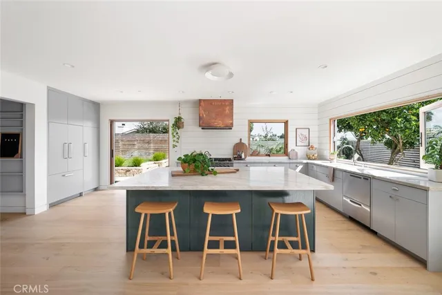 a kitchen with stainless steel appliances granite countertop a sink a stove and a refrigerator