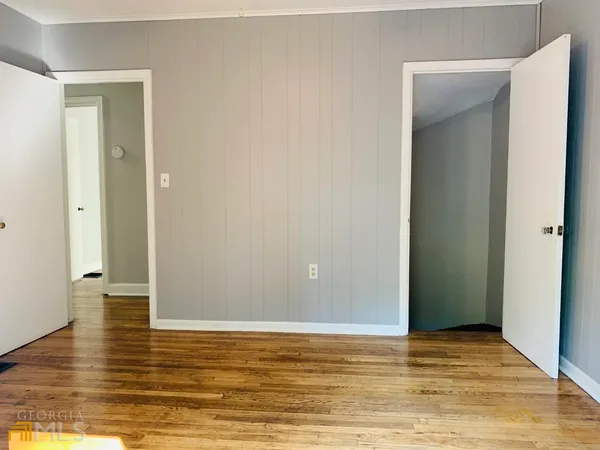a view of empty room with wooden floor and window