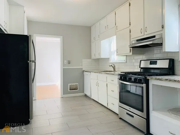 a kitchen with stainless steel appliances granite countertop a refrigerator and a stove