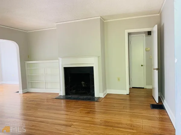a view of a livingroom with wooden floor and a fireplace
