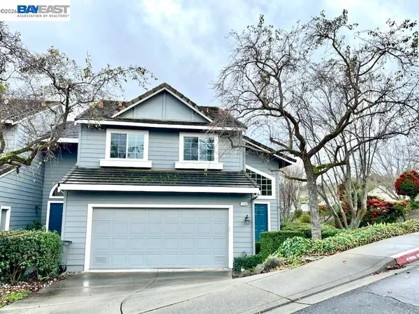a front view of a house with a garden and trees