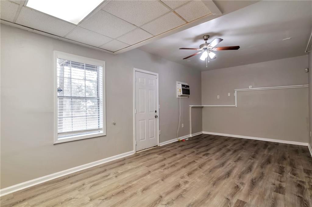 5918 Crescent Ridge Court Lithonia, GA 30058 - Photo 19 of 25 an empty room with wooden floor chandelier fan and windows