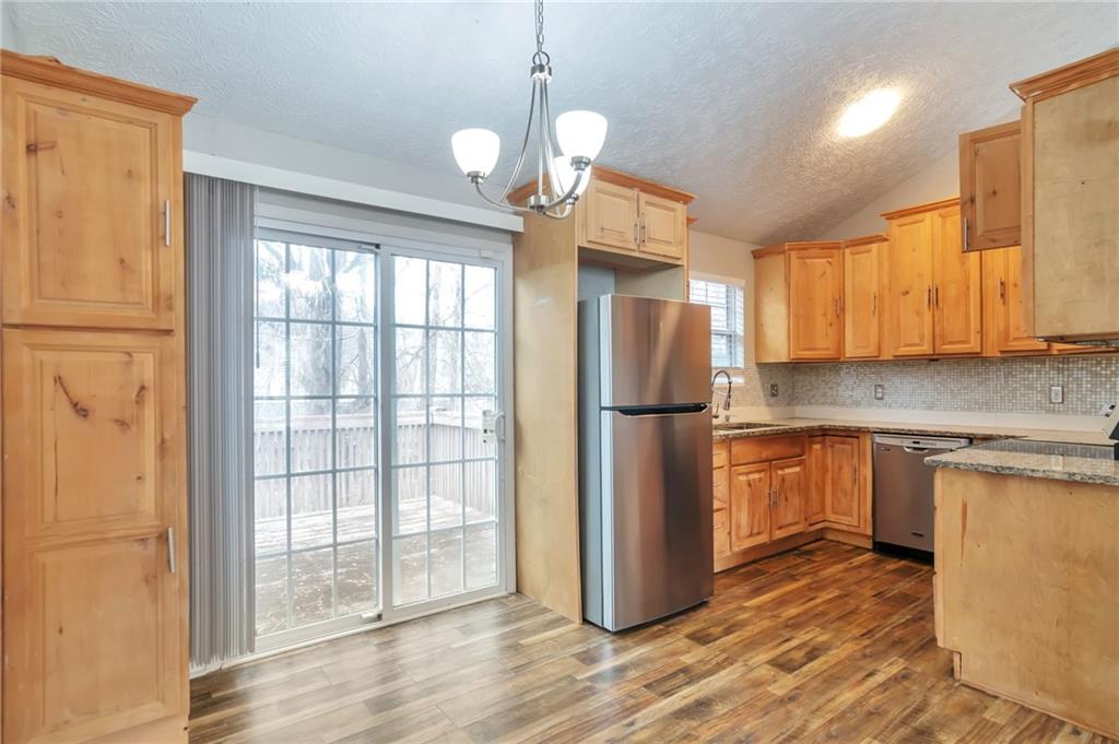 5918 Crescent Ridge Court Lithonia, GA 30058 - Photo 5 of 25 a kitchen with stainless steel appliances granite countertop a refrigerator a sink dishwasher a stove with wooden cabinets and floor
