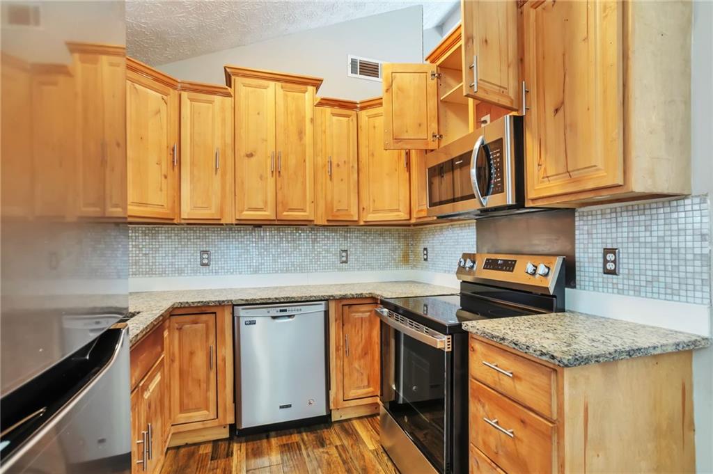 5918 Crescent Ridge Court Lithonia, GA 30058 - Photo 7 of 25 a kitchen with stainless steel appliances granite countertop a sink and cabinets