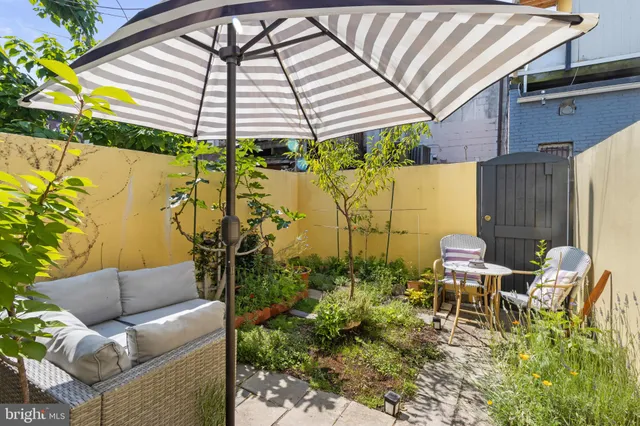a backyard of a house with table and chairs potted plants