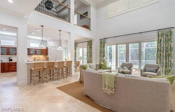 428 Rudder Road Naples, FL 34102 - Photo 9 of 49 Living area with ornamental molding, a high ceiling, recessed lighting, and french doors