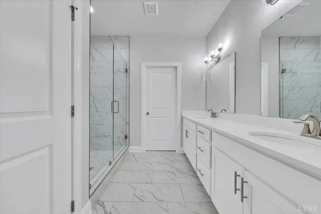 a spacious bathroom with double vanity and mirrors