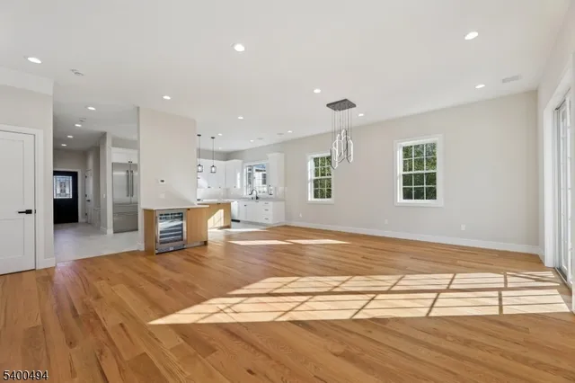 a view of a kitchen with kitchen island a sink wooden floor and a refrigerator
