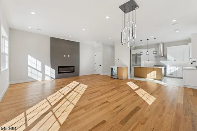 a large kitchen with stainless steel appliances kitchen island granite countertop a refrigerator a sink dishwasher a stove and white cabinets