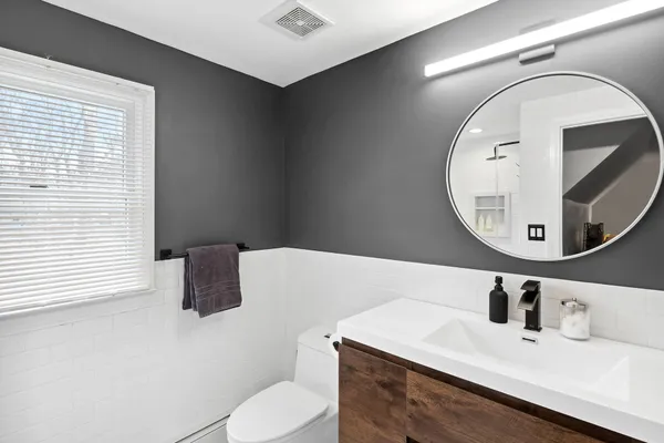 a bathroom with a sink vanity mirror and toilet