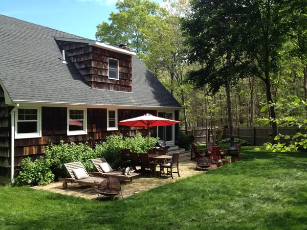 a view of a house with backyard sitting area and garden