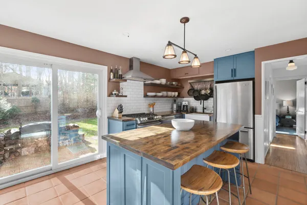 a kitchen with granite countertop a table chairs stove and refrigerator