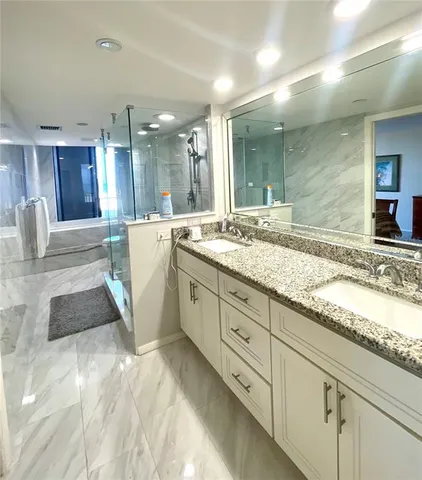 a bathroom with a granite countertop sink a toilet and shower