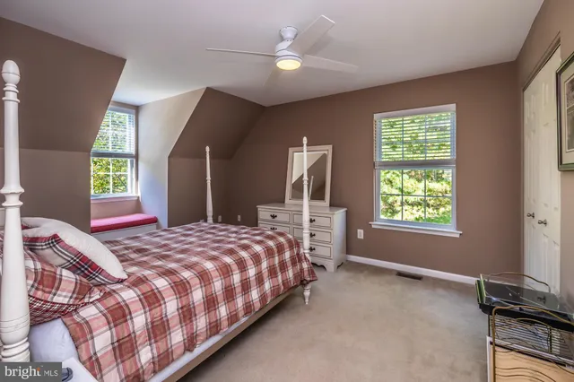 a bedroom with a bed desk and a window