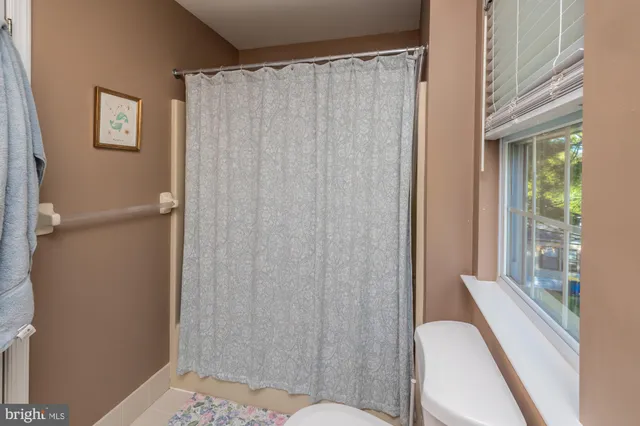 a bathroom with a shower curtain and a toilet