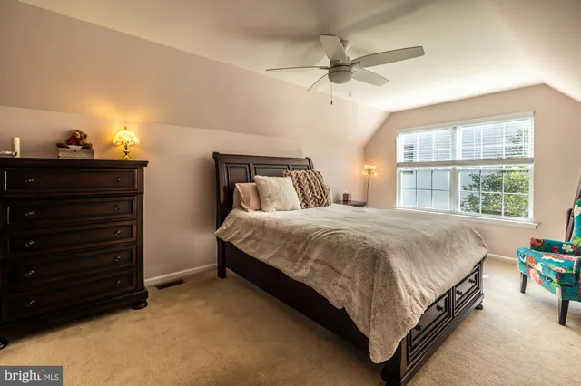 a bed sitting in a bedroom next to a window and a chandelier