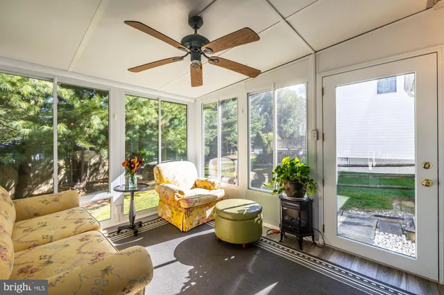 a living room with patio furniture and a potted plant