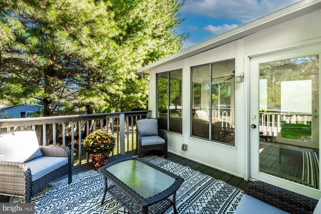 a balcony with wooden floor table and chairs