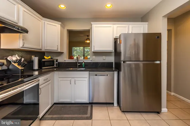 a kitchen with a refrigerator a sink and cabinets