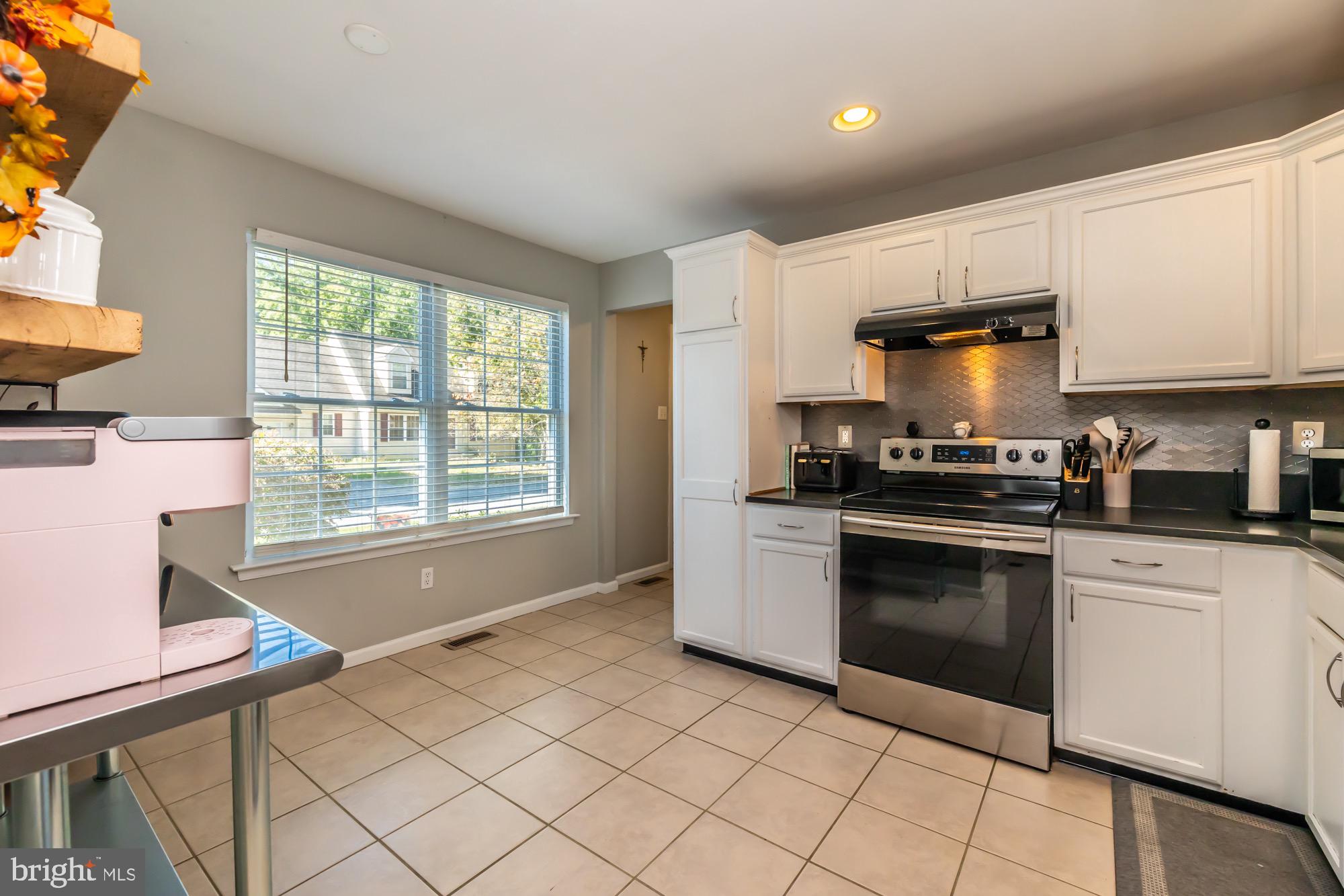 31 North Hawthorne Road Coatesville, PA 19320 - Photo 8 of 41 a kitchen with granite countertop a stove a sink and a microwave