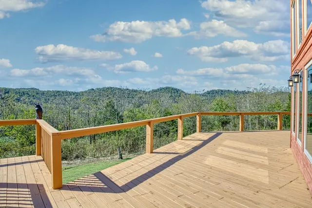 a view of balcony with wooden floor and fence