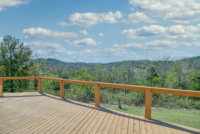 a view of a balcony with wooden floor & fence
