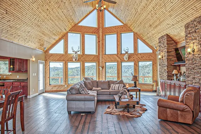 a living room with furniture a fireplace and large windows