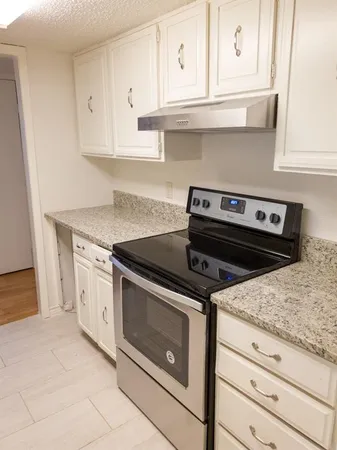 a stove top oven sitting inside of a kitchen