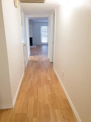 a view of a hallway with wooden floor