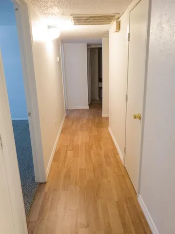 a view of a hallway with wooden floor