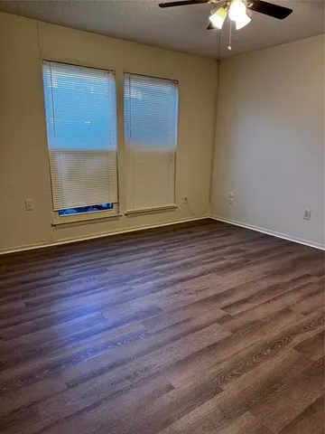 a view of room with wooden floor and fan