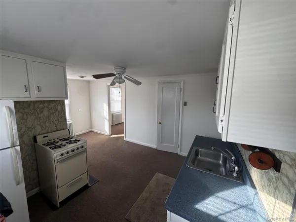 a kitchen with a refrigerator and a stove top oven