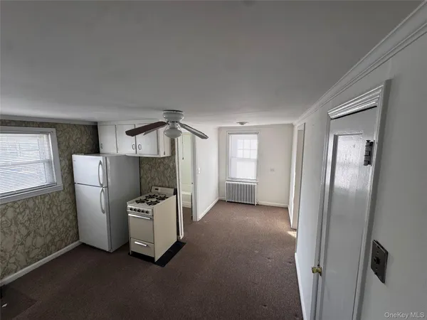a view of a kitchen with refrigerator and window