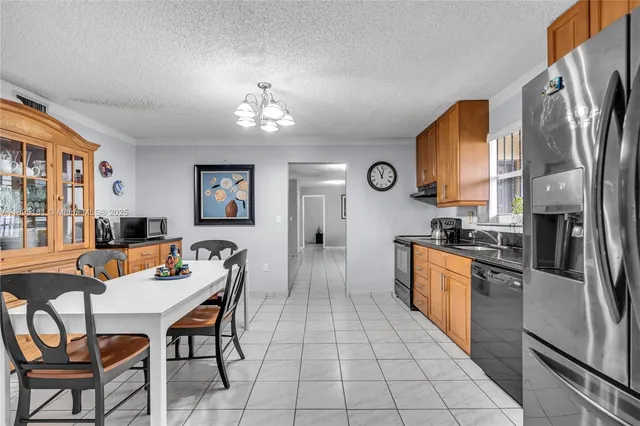 a kitchen with stainless steel appliances granite countertop a refrigerator and a stove top oven
