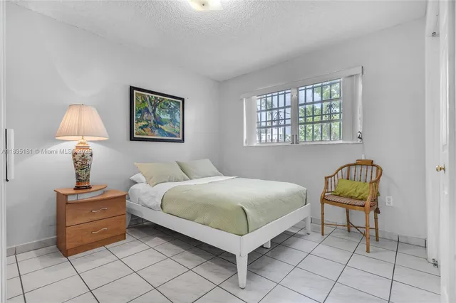 a bedroom with a bed and a lamp on table