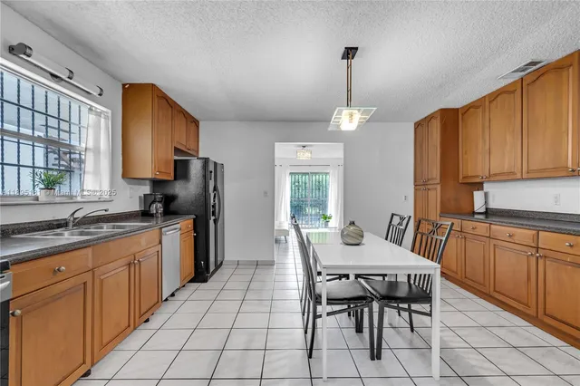 a kitchen with granite countertop a sink stove and refrigerator