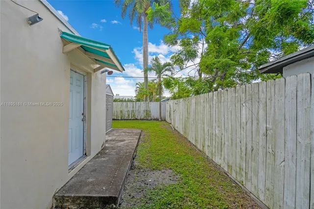 a view of backyard with garden and wooden fence