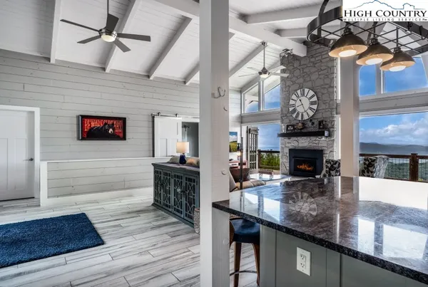 a kitchen with stainless steel appliances granite countertop a sink dishwasher and a fireplace with wooden floor
