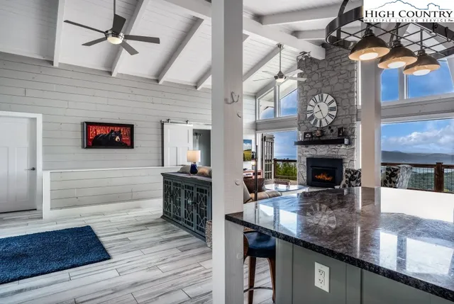 a kitchen with stainless steel appliances granite countertop a sink dishwasher and a fireplace with wooden floor