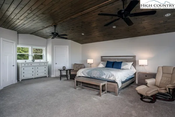 a spacious bedroom with a bed and a chandelier